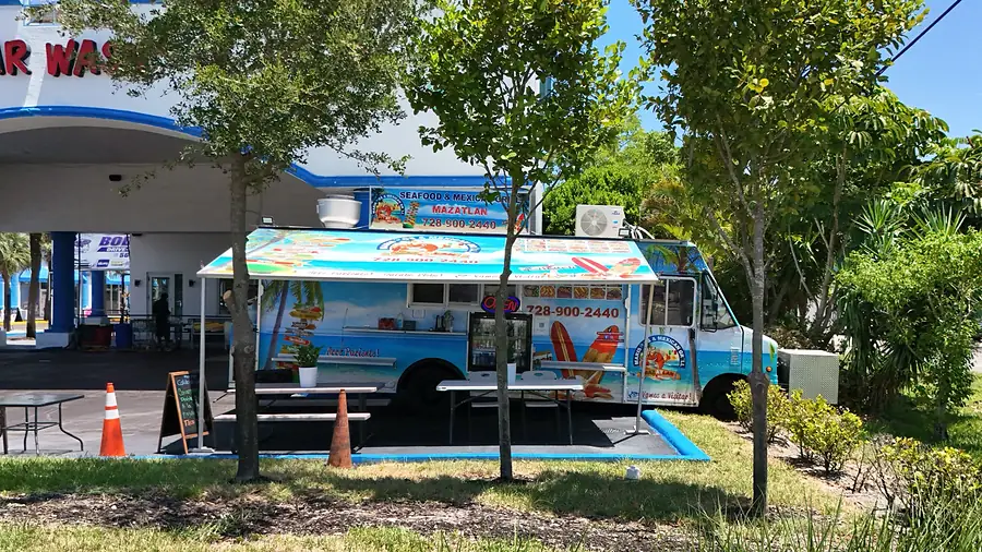 The Mariscos Mazatlan truck parked in front of the Diamond Auto Salon car wash, with the CAR WASH sign behind it.